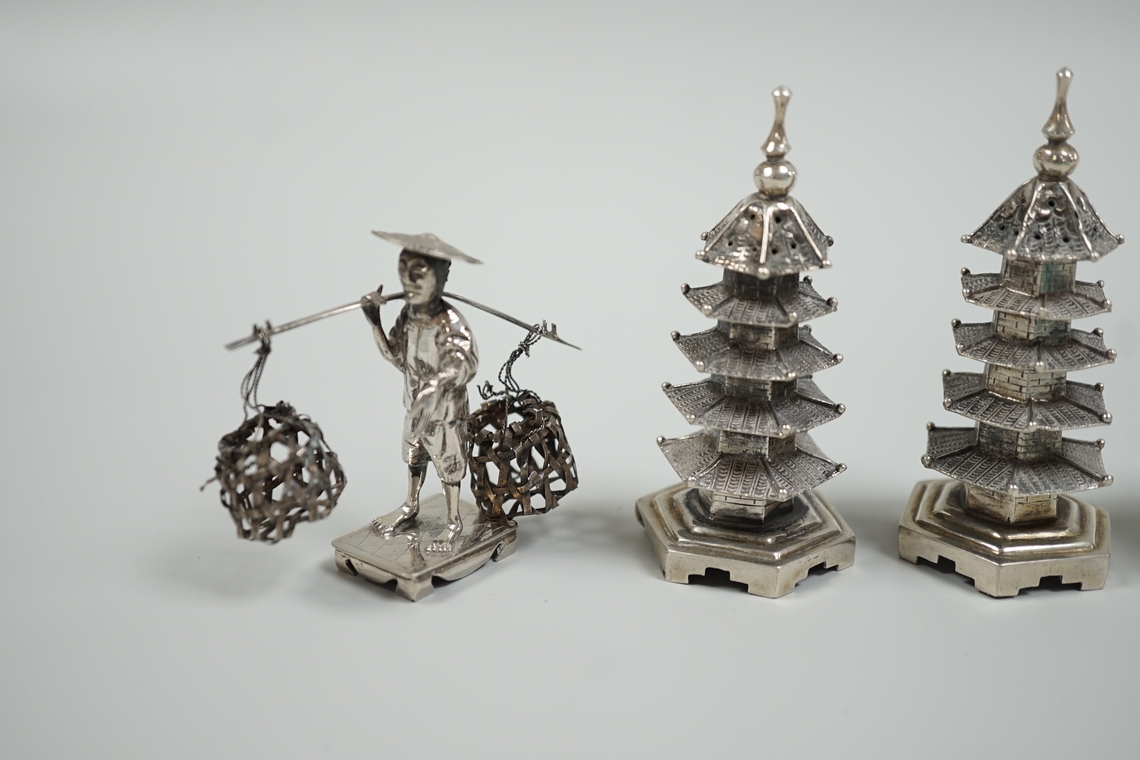 A Chinese white metal 'wedding basket' by Wang Hing, 63mm, a pair of similar white metal pagoda condiments, KSM and a figure.